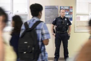 School Resource Officer standing in a hallway with students