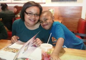 Photo of Atatiana smiling at a table with a young boy