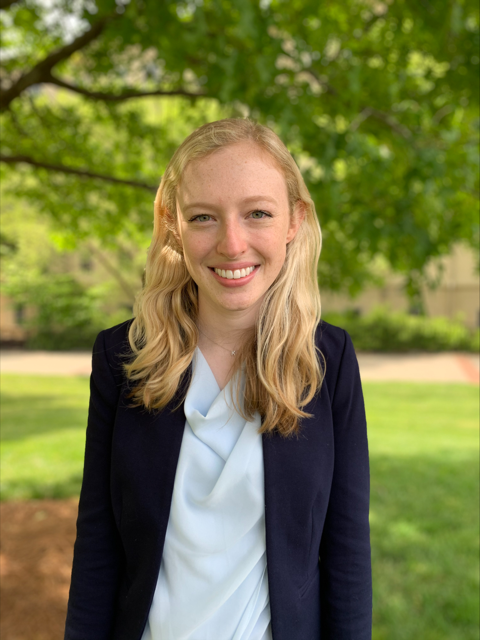 Photo of Katie smiling outside in a white top and black blazer